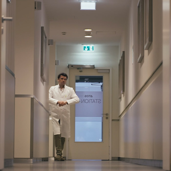 Dr. Hudek läuft einen Flur entlang in der ATOS Klinik Hamburg Fleetinsel